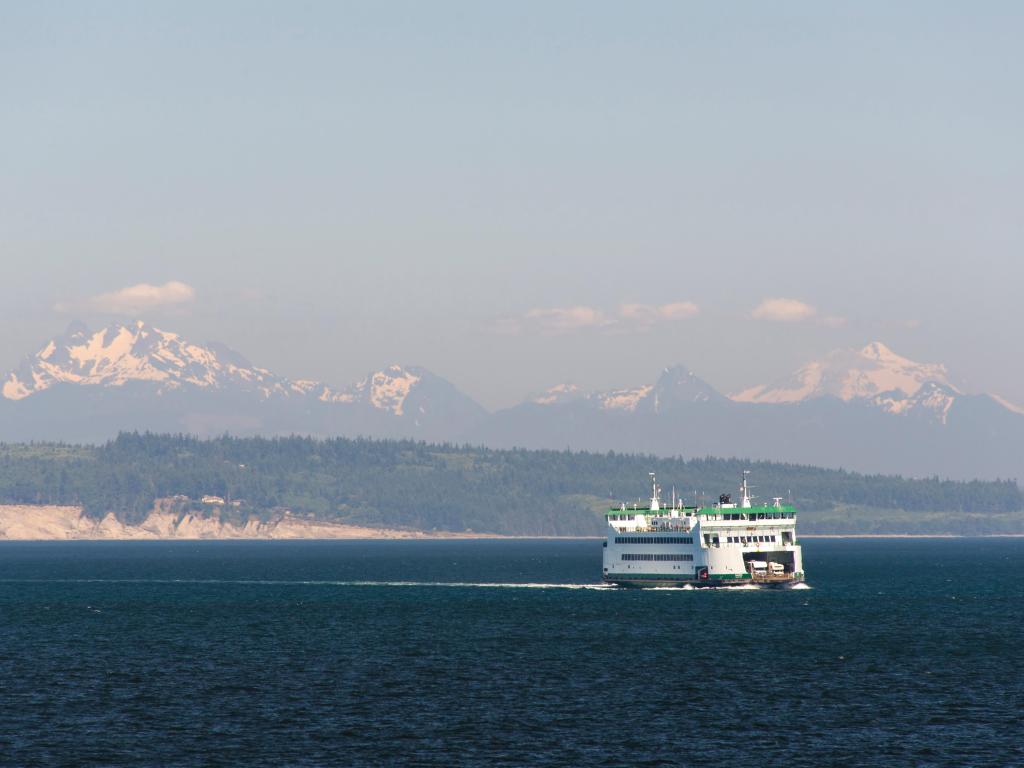 State ferry transports cars and passengers between Whidbey and Port Townsend with majestic vistas of North Cascades beyond.