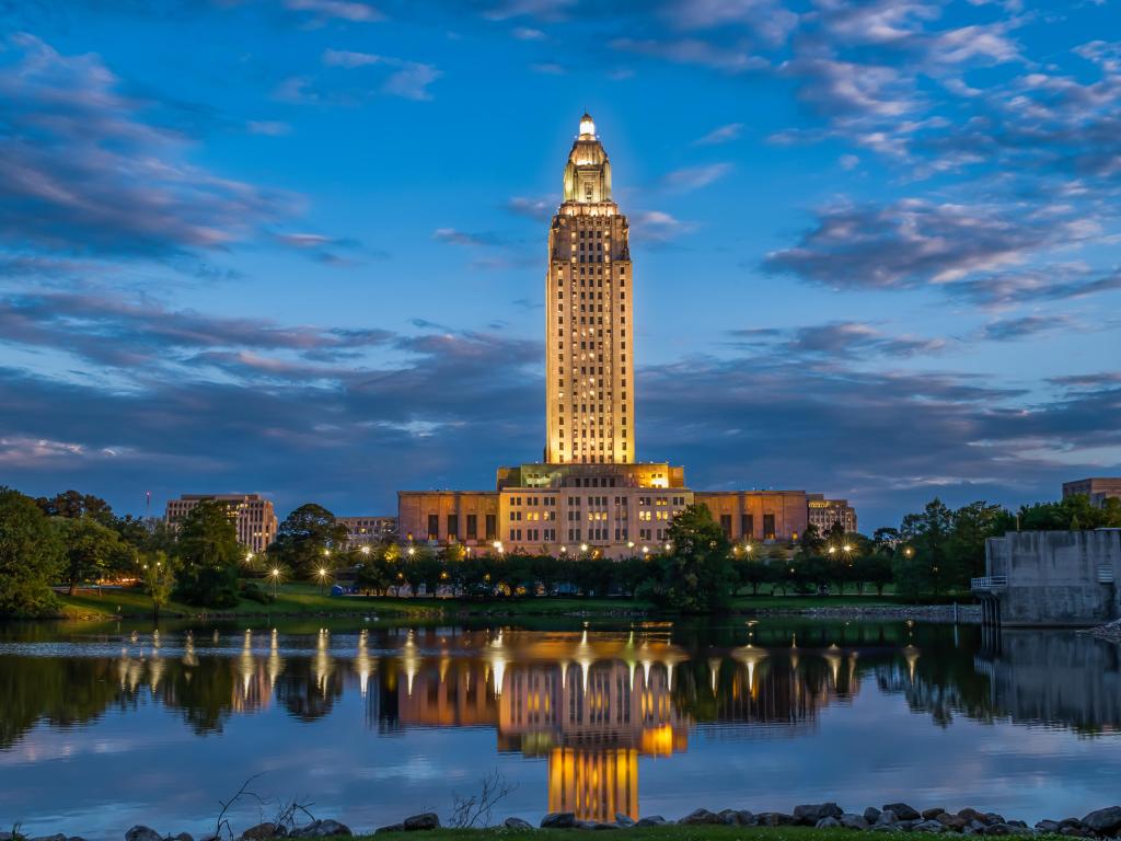Baton Rogue, Louisiana, USA taken at early evening with the Louisiana State Capitol in the background reflecting in a lake in the foreground.