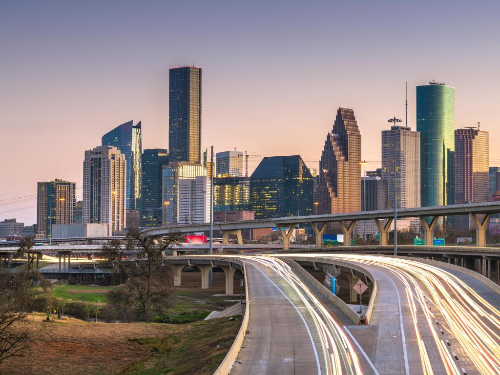 Houston, Texas, USA downtown city skyline and highway at dusk.