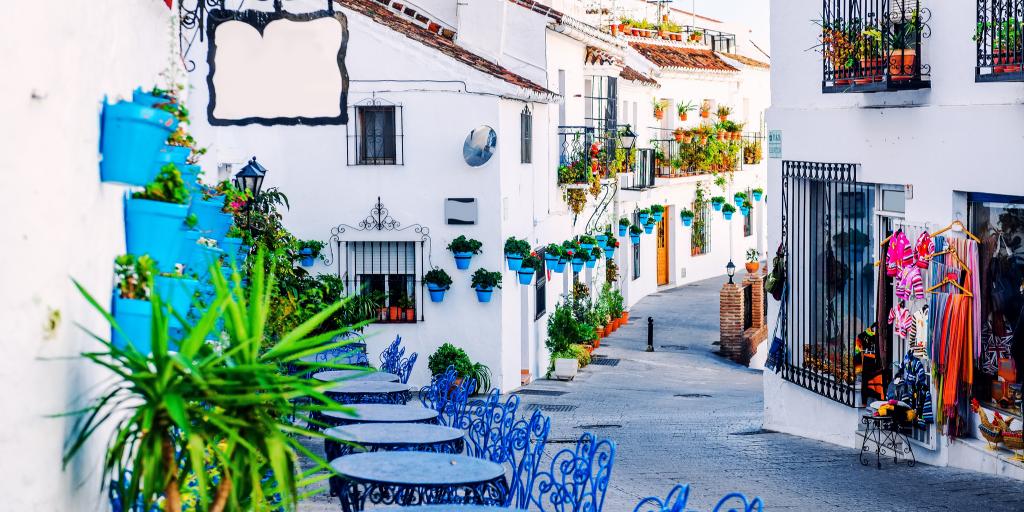 Blue tables and chairs line the charming streets of Mijas