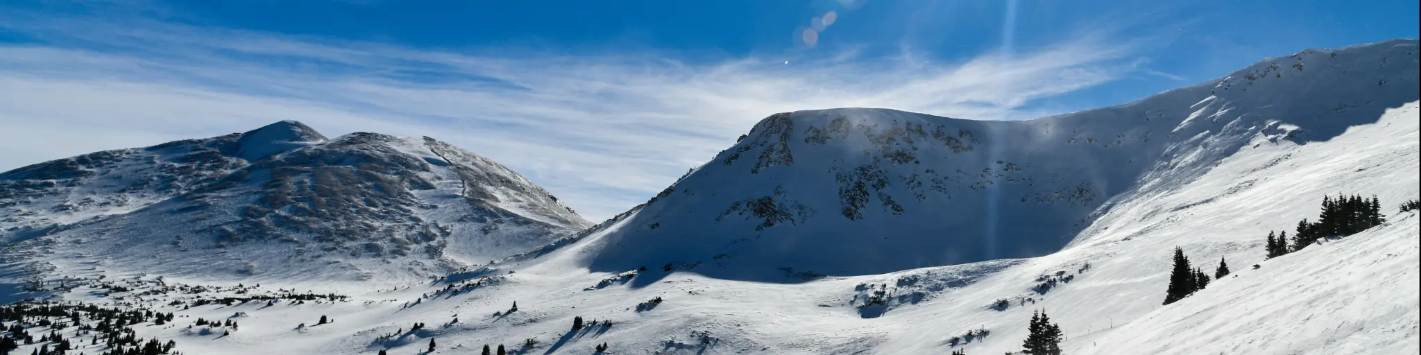 Breckenridge Colorado mountain view, with snow glistening in the bright sun and a blue sky above