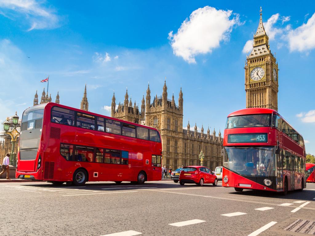 Red London Buses in front of the Houses of Parliament and Big Ben in London, UK