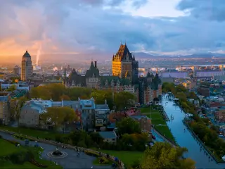 Canadian Flag flying over Old Quebec City at sunset, with clouds above