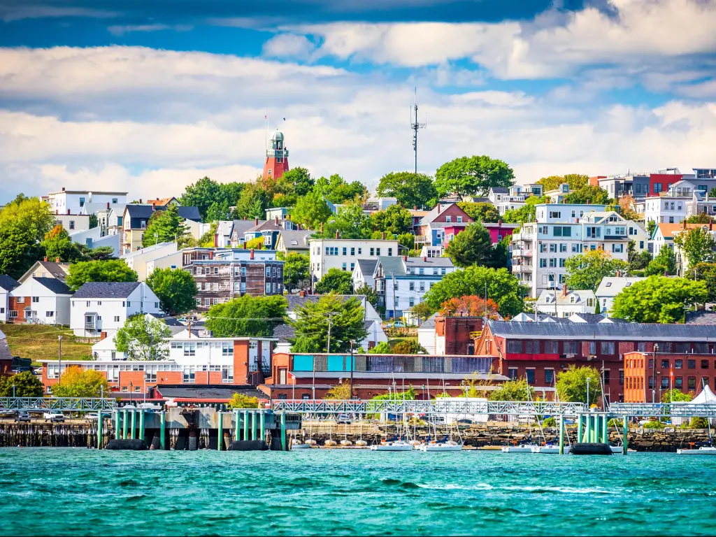 Portland, Maine, USA showing the coastal townscape in the background, the turquoise sea in the foreground and taken on a sunny day.