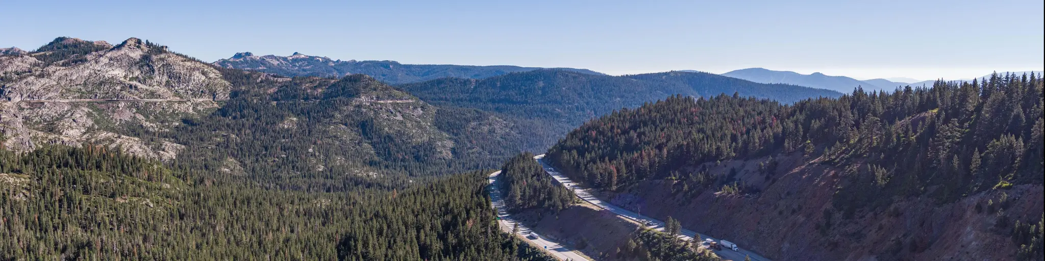 Aerial, panoramic View of I-80 cutting through the forest near Truckee California