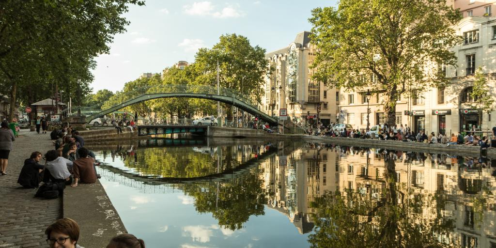 People sit and chat along the banks of Canal Saint-Martin in Paris