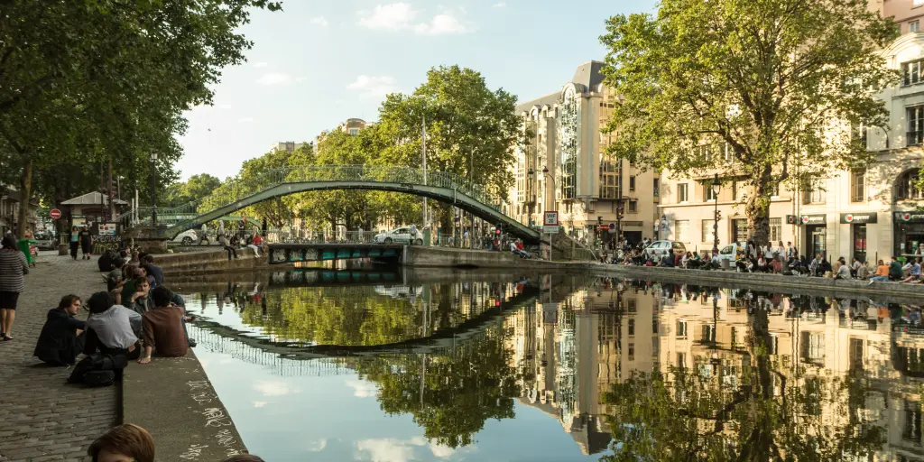 People sit and chat along the banks of Canal Saint-Martin in Paris