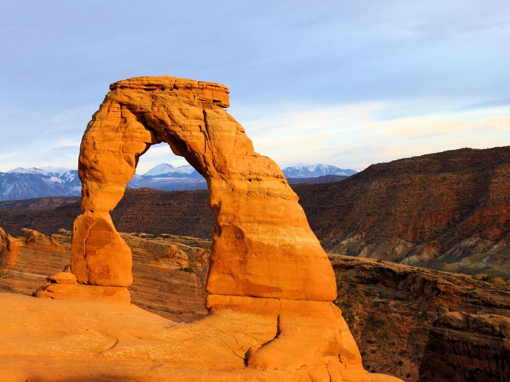 Arches National Park, Utah, USA taken at the Delicate Arch with snow-capped mountains in the distance.