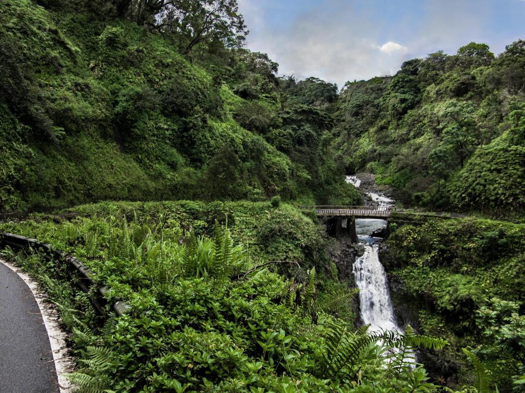 The Hana Highway turns to cross a one lane bridge beside a waterfall on the north coast of Maui, Road to Hana, Hawaii