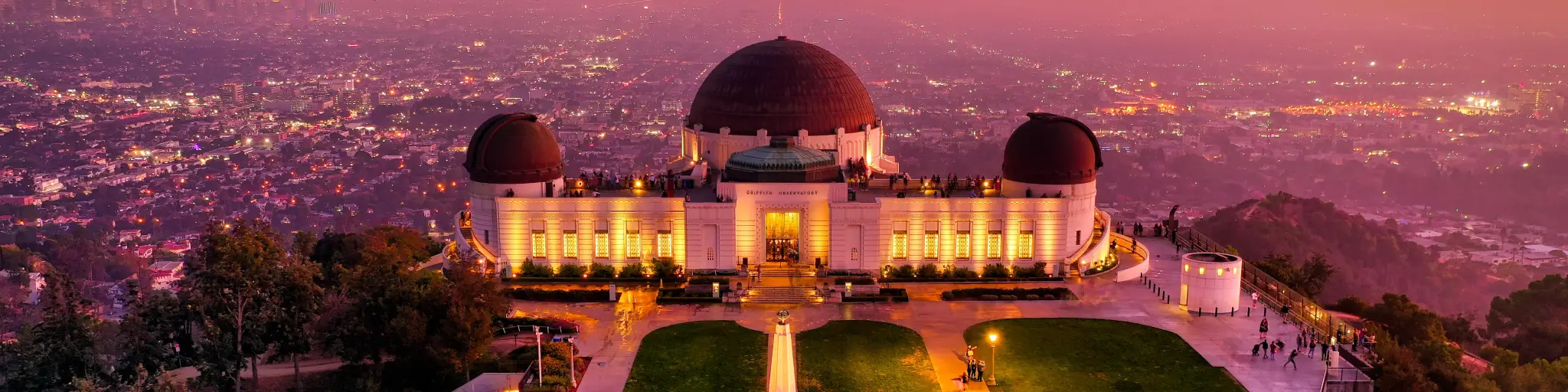 A very late pink sunset photo of Griffith Observatory with all the lights of the building turned on