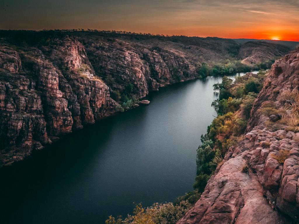 Katherine, Northern Territory Australia with a sunrise at Nitmiluk gorge, river in the foreground and cliffs between it.