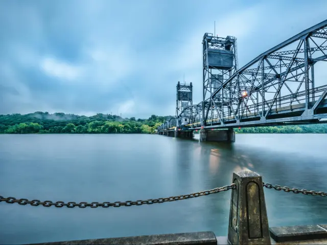 Stillwater, MN, USA with an overcast sunrise at St Croix River, and trees in the distance. 