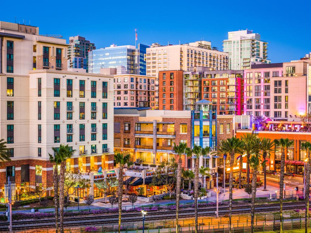 San Diego, California, USA cityscape at the Gaslamp Quarter with palm trees in the foreground and taken at dusk.