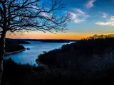 Eureka springs sunset at lake with trees in the foreground
