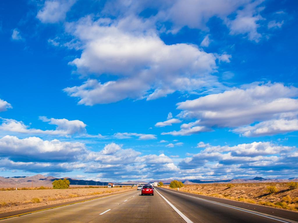 A busy road of Interstate 15 with cars in the road in a blue, cloudy, sunny weather