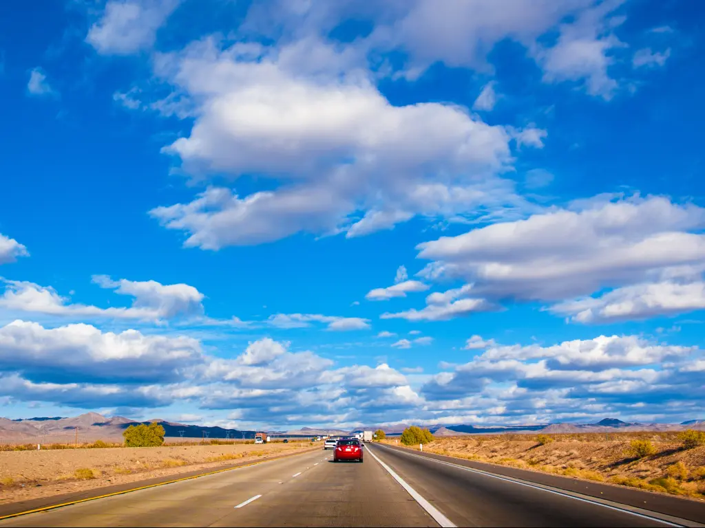 A busy road of Interstate 15 with cars in the road in a blue, cloudy, sunny weather