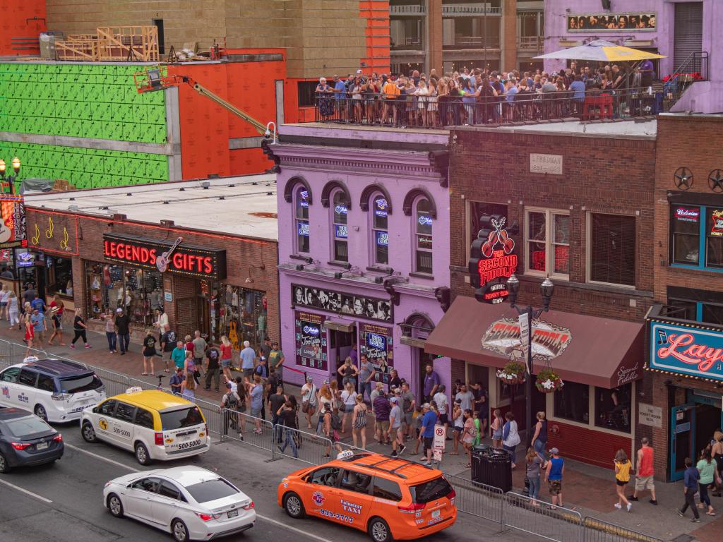 A crowd of people enjoy some live music at a rooftop bar in Nashville, TN
