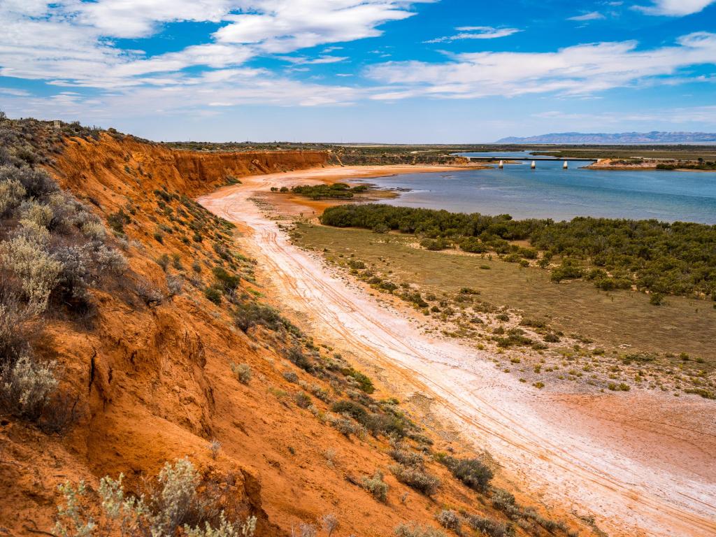 Port Augusta, South Australia taken at Matthew Flinders Red Cliff Lookout on a sunny day with water in the distance.
