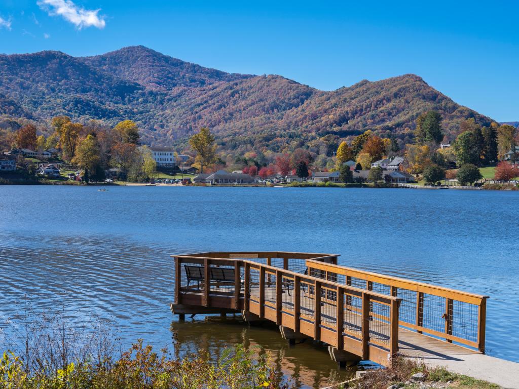 Fall colors over the lake in colorful park, with a deck in the foreground