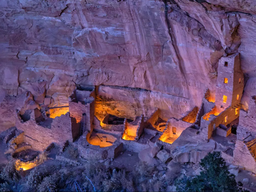 Historic houses carved into the cliff face are illuminated after dark and viewed from a high vantage point