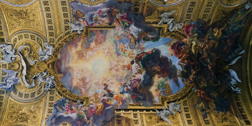 The ceiling fresco at Chiesa del Gesù, with a gold barrel shape and angels appearing to descend from the ceiling