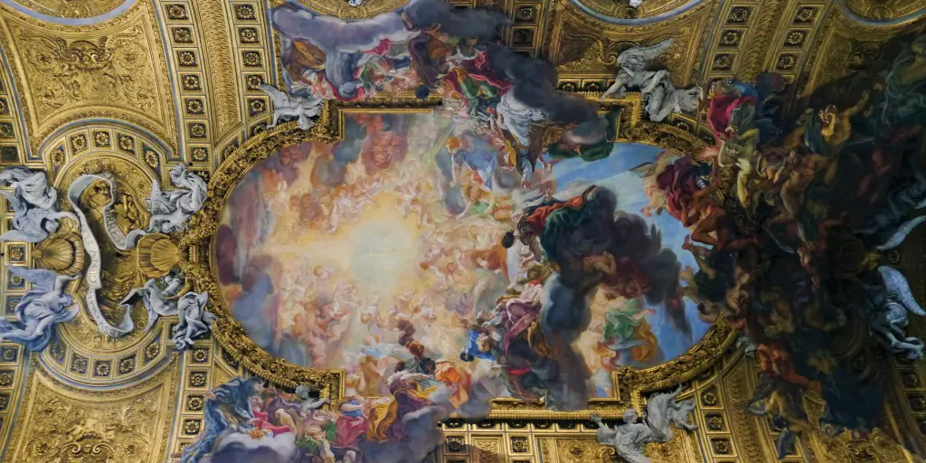 The ceiling fresco at Chiesa del Gesù, with a gold barrel shape and angels appearing to descend from the ceiling
