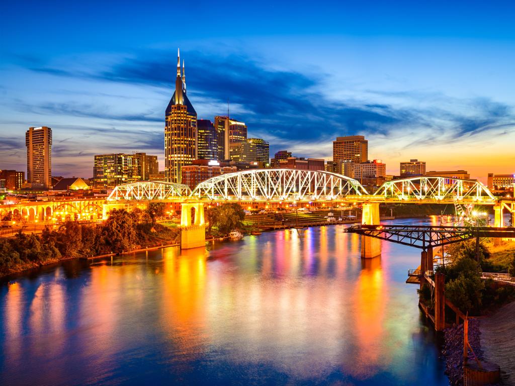 River through the city with highrise downtown buildings behind and bridge crossing, at sunset