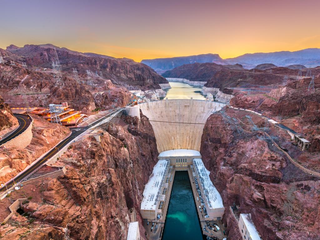 Hoover Dam on the Colorado River straddling Nevada and Arizona at dawn from above.