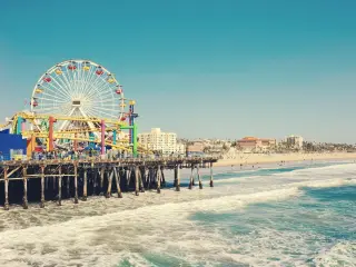 View of Pacific Park on Santa Monica Pier with waves crashing on the beach