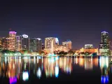 Orlando downtown skyline panorama over Lake Eola at night with urban skyscrapers and clear sky.