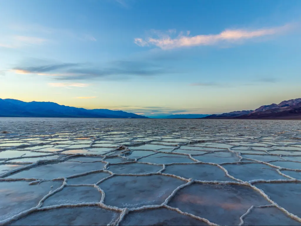 Badwater Basin Salt Flats, Death Valley National Park, California, USA at sunset with salt crust and clouds.