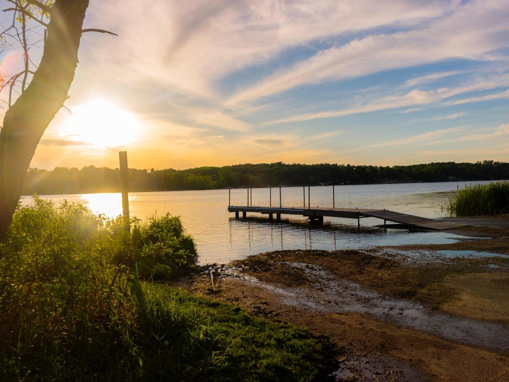 Long Lake Recreation Area in Kettle Moraine State Forest in Kewaskum, Wisconsin at sunset with a jetty and trees in the distance. 