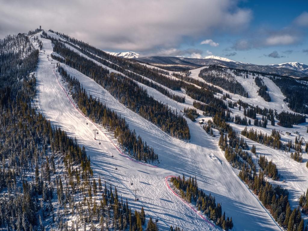 Aerial view of the ski town with chair lifts going to the top of the hill among forests