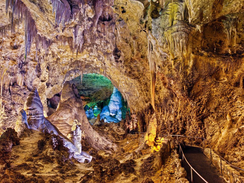 Walkway through vast cave with stalactites and stalacmites