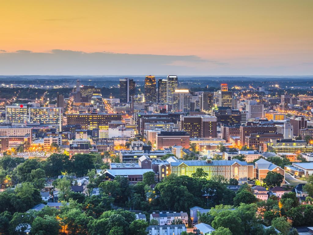 Birmingham, Alabama, USA downtown skyline taken at early evening with trees in the foreground.