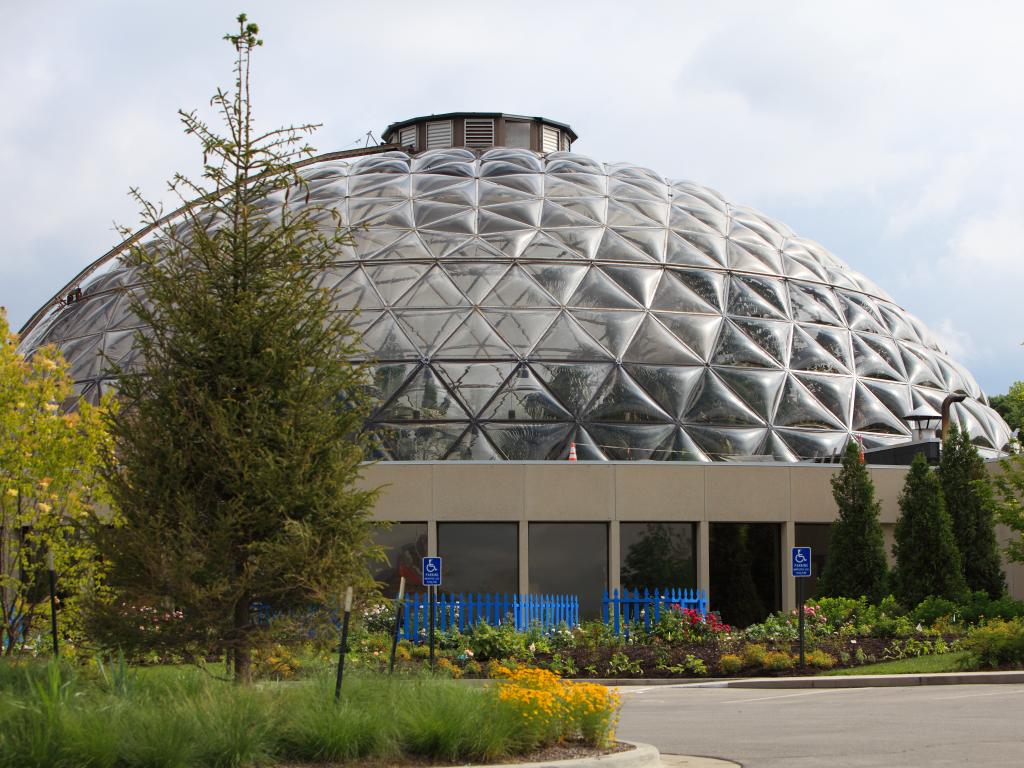 The stunning Des Moines Botanical Garden Environmental Center in Iowa with made of a glass dome and a series of beautiful flowers around it during summer