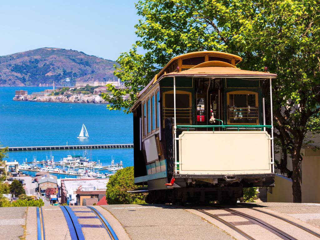 San Francisco, California, USA with a Cable Car overlooking the sea and mountains in the distance on a sunny day.