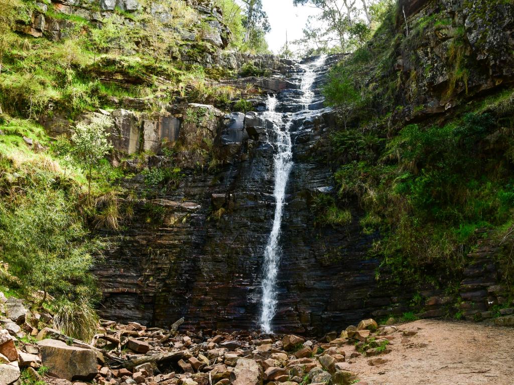 Grampians National Park, Australia with a waterfall in the centre and surrounded by rocks and green foliage.