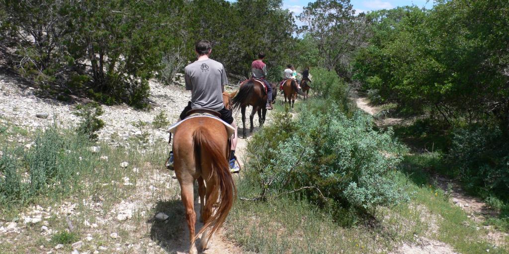 A back view of people horse riding at Silver Spur Ranch, Texas