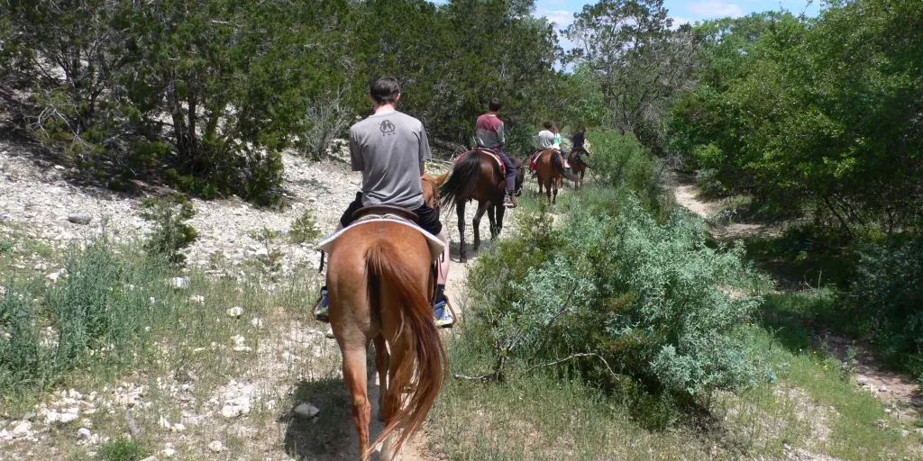 A back view of people horse riding at Silver Spur Ranch, Texas