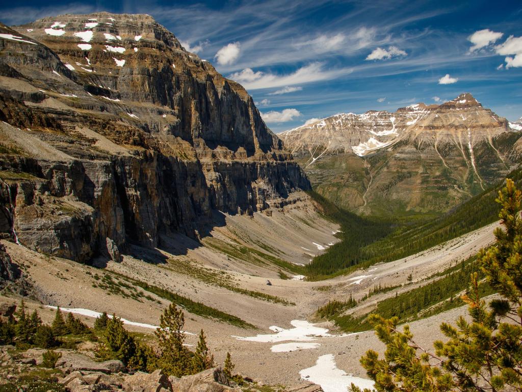 Yoho National Park, Canada taken at Valley of Stanley Glacier with snow on the mountains and valley, trees in the foreground and taken on a sunny day.