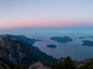 Panoramic view of Howe Sound, North of Vancouver, taken at sunset from the top of a mountain with a little snow remaining, showing the ocean and small islands