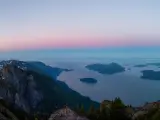 Panoramic view of Howe Sound, North of Vancouver, taken at sunset from the top of a mountain with a little snow remaining, showing the ocean and small islands