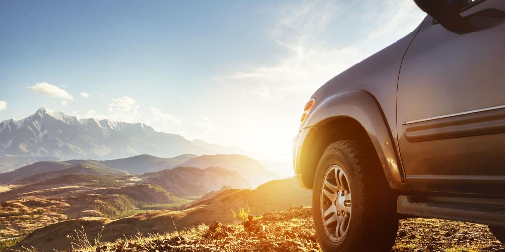 The front of an SUV parked overlooking mountains