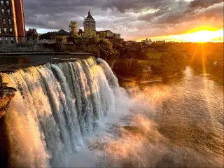 Rochester skyline during sunset with the famous waterfalls in the foreground