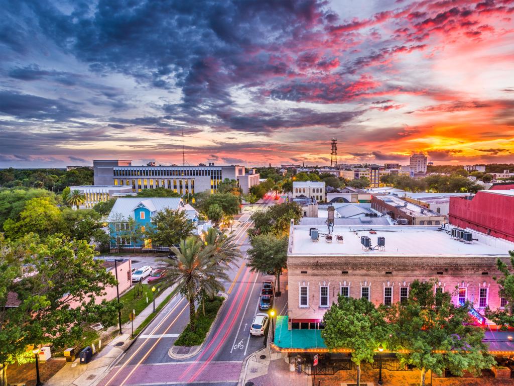 Gainesville, Florida, USA downtown cityscape at sunset with a stunning sky and tree lined streets.