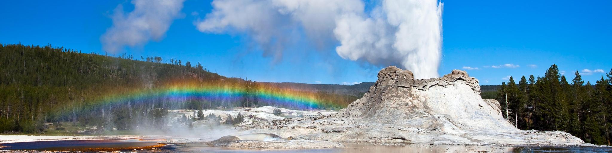 Rainbow near Castle geyser on a clear day, Yellowstone National Park, Wyoming, USA. 