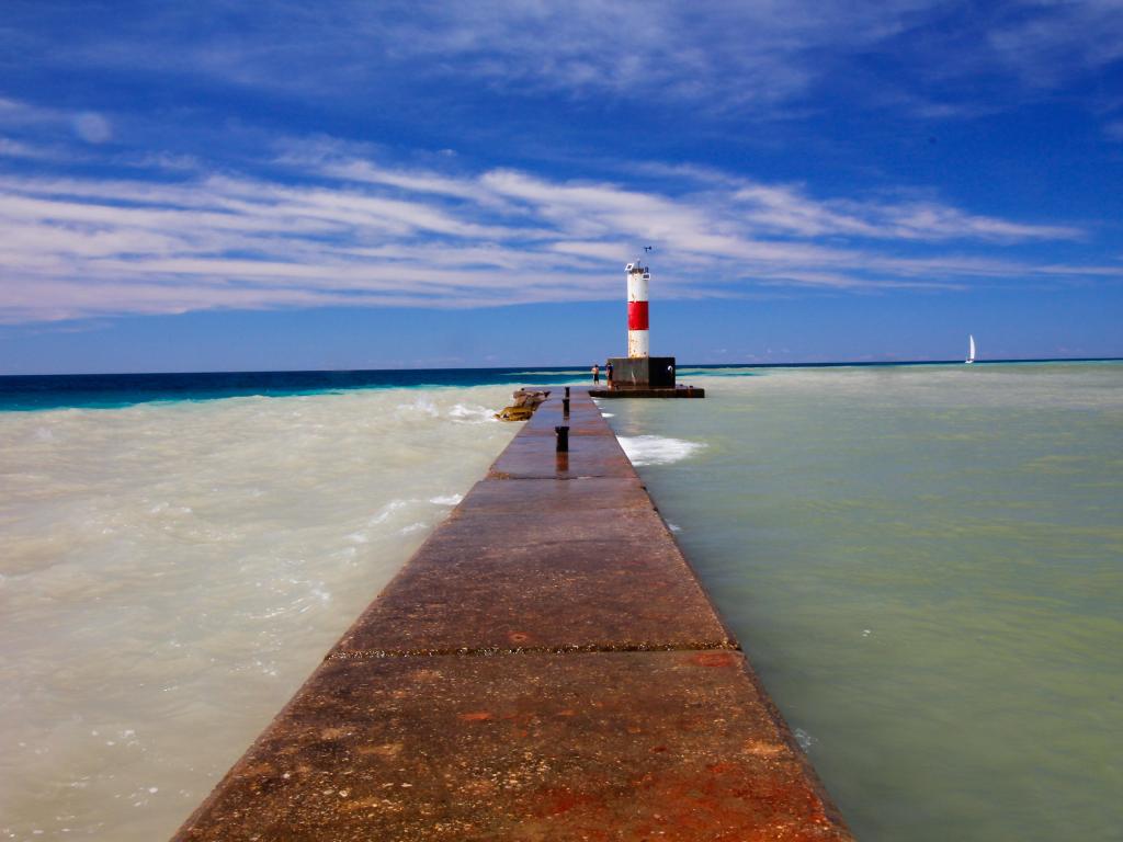 Traditional lighthouse standing in the middle of bright blue waters at Lake Michigan