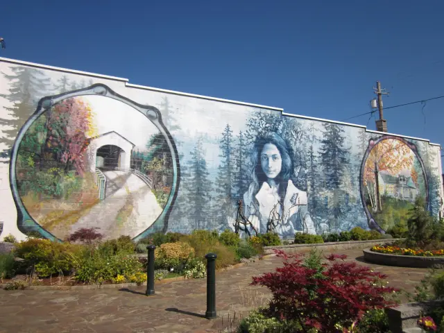 Beautiful mural depicting Cottage Grove's famous landmarks and a young woman covered in butterflies