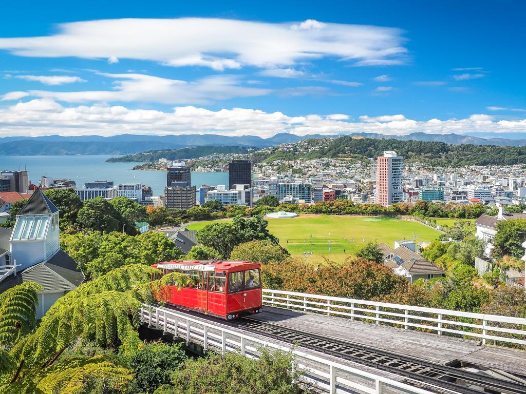 Wellington, New Zealand with a view of the red Wellington Cable Car, the landmark of New Zealand and the city and coast in the distance.